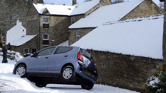 A car balances on 2 wheels after miss judging a corner today in Allendale, Northumberland.
