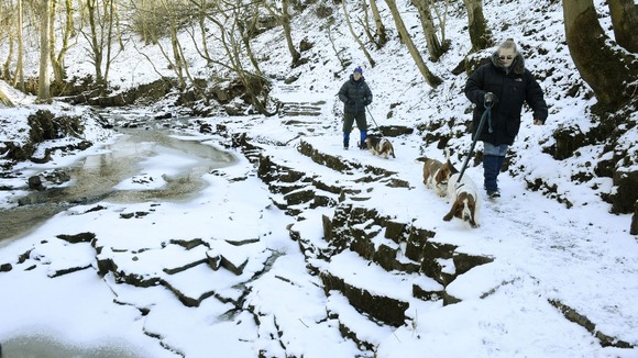 Dog walkers at the Bow Lee Beck waterfall at Gibson's Cave in Teesdale which has frozen
