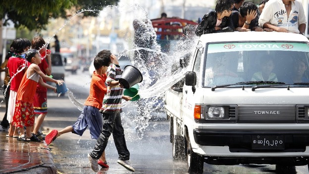 Children throw water at passing traffic in central Yangon