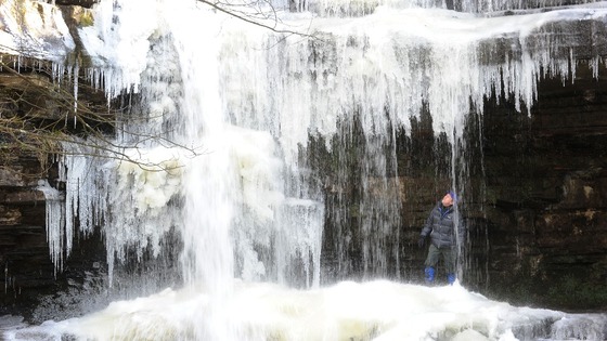 A man looks at the icicles formed on the Bow Lee Beck waterfall at Gibson's Cave in Teesdale.