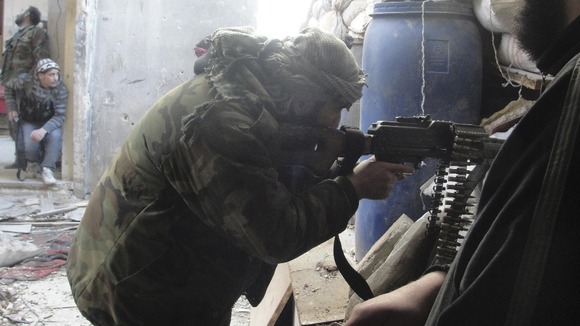 A Free Syrian Army fighter aims his weapon in the Al-Khalidiya neighbourhood of Homs
