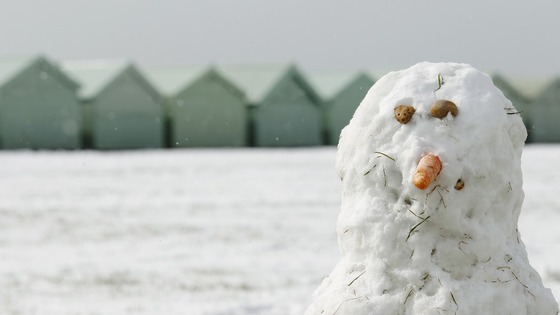 A snowman surveys the wintry vista on Brighton beach