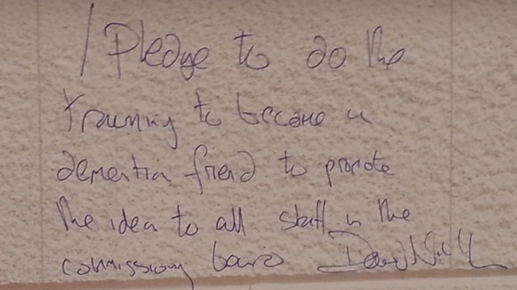 Sir David Nicholson wrote on a wall to promise to training to become 'a dementia friend'