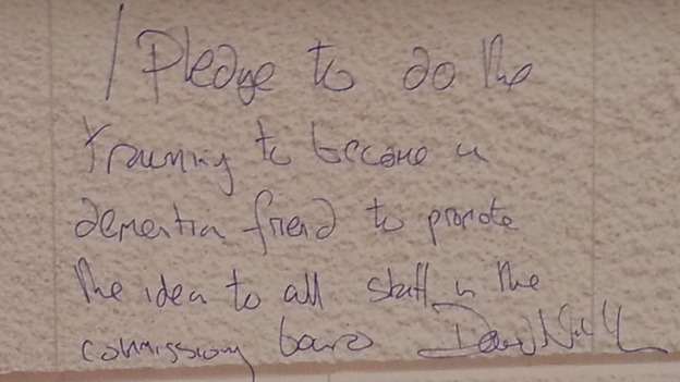 Sir David Nicholson wrote on a wall to promise to training to become 'a dementia friend'