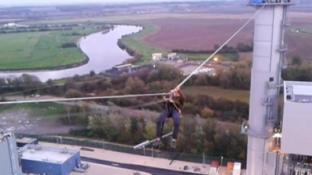 A man dangles between chimneys