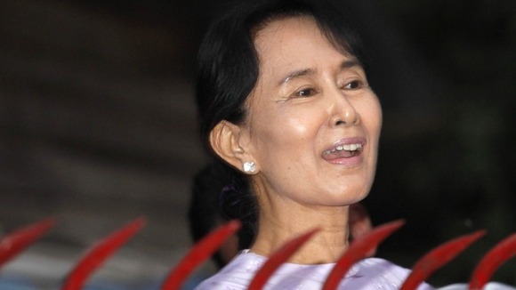 Ms Suu Kyi speaks to supporters over the fence of the compound where she was under house arrest