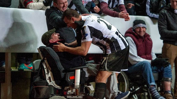 Newcastle United's Steven Taylor celebrates with a fan after the final whistle