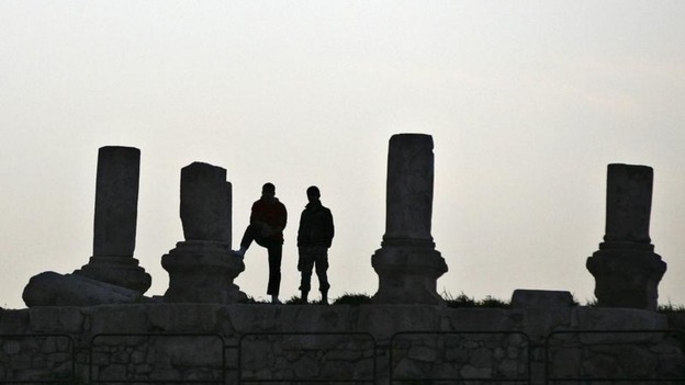 Security guards watch over children in Amman as they prepare for a moment of silence
