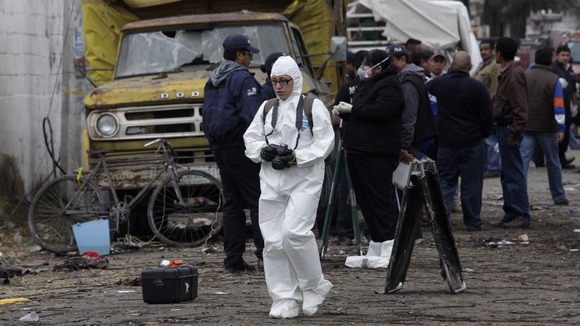 A member of the forensics team walks near the site of the explosion.