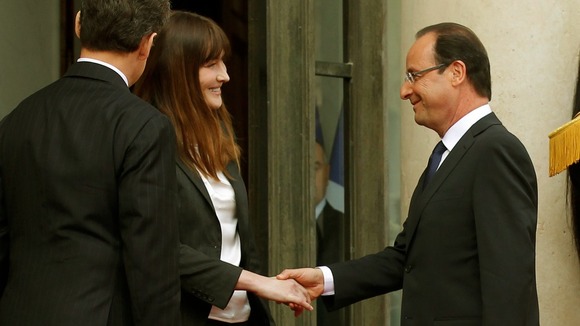 France's former First Lady Carla Bruni shakes hands with incoming President Francois Hollande