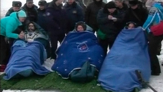 NASA's Kevin Ford and Russian cosmonauts Oleg Novitskiy and Evgeny Tarelkin wrapped in blankets after leaving the Soyuz space capsule