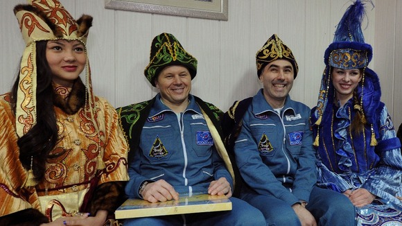 Oleg Novitskiy and Evgeny Tarelkin dressed in Kazakh traditional clothing after touching back down on Earth