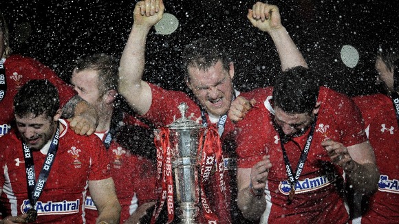 Welsh players Leigh Halfpenny (left), Gethin Jenkins (centre) and Alex Cuthbert (right) celebrate after lifting the trophy.