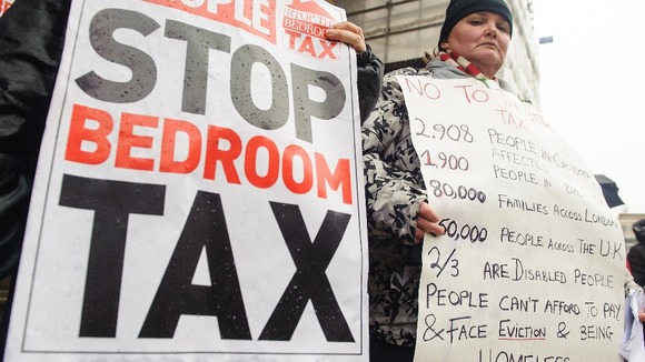 Protesters hold up signs against the bedroom tax