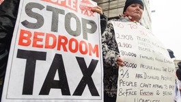 Protesters hold up signs against the bedroom tax