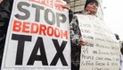Protesters hold up signs against the bedroom tax