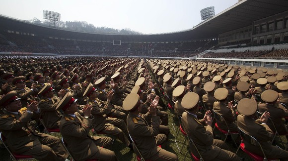 A crowd of North Korean military members applaud the country's leader Kim Jong Un.