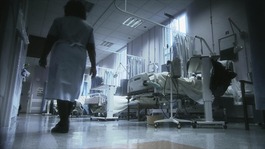 Nurse walking along in hospital ward