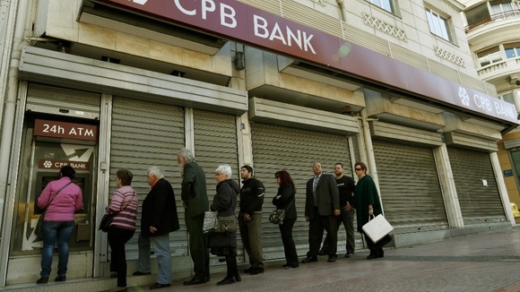 Customers queue to take out cash from the Cyprus Popular Bank