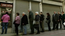 Customers queue to take out cash from the Cyprus Popular Bank 