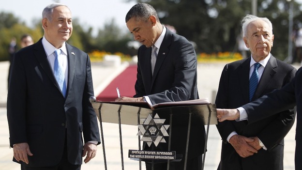 President Obama, flanked by Israel's President Shimon Peres (R) and Prime Minister Benjamin Netanyahu, writes in a guest book