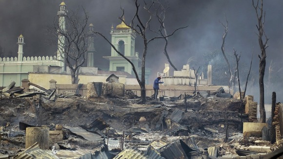 A man stands in front of a burnt-out mosque in Meikhtila, central Myanmar