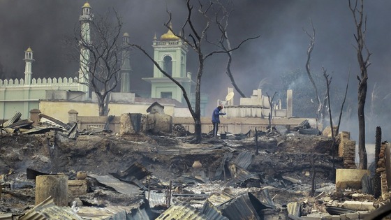 A man stands in front of a burnt-out mosque in Meikhtila, central Myanmar