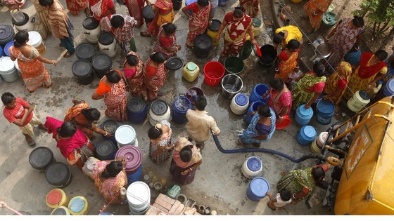 People collect drinking water from a water tanker in Kolkata, India