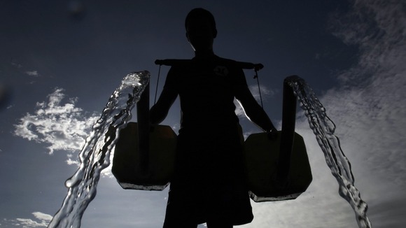 A Filipino farmer pours water in Taguig City. Agriculture is the largest single use of water.