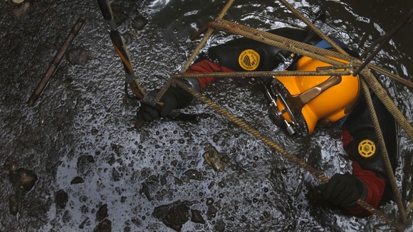 Julio Cu Camara is lowered done into the city's sewer system