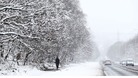 A man walks along a snowy road in Leeds, Yorkshire.