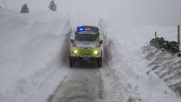 An Oldham Mountain Rescue vehicle drives through a snow drift.