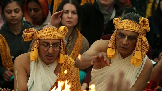 Hare Krishna priests pour sanctified offering of clarified butter into a sacred fire.