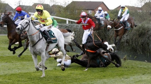 According to Pete ridden by Harry Haynes (in red) falls after jumping Becher's Brook in the Grand National