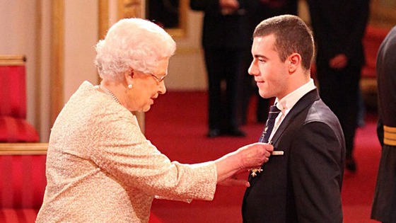 Paralympic gold medallist Josef Craig is handed his honour by the Queen.