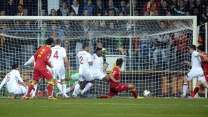 Montenegro's Dejan Damjanovic (centre right) levels during the Group H match in Podgorica
