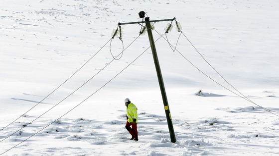 An engineer walks past a damaged power line in Kintyre in Scotland