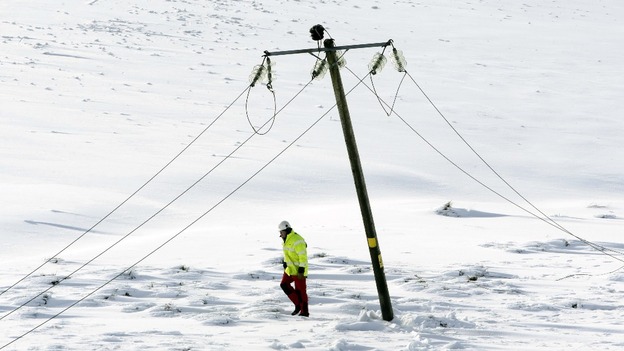 An engineer walks past a damaged power line in Kintyre in Scotland