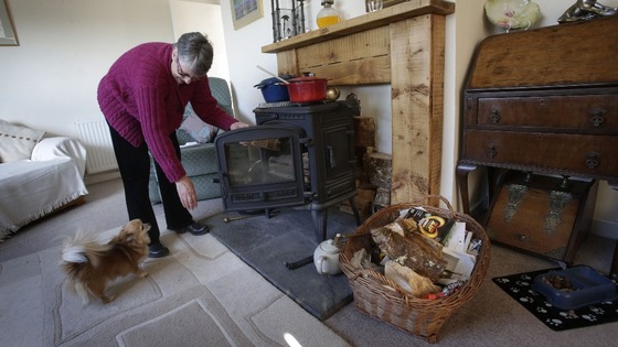 Janette Hamilton cooks on a wood burning stove at her home in Southend in Scotland after loosing her power supply