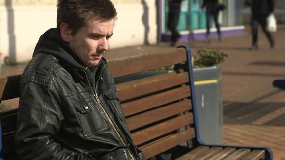 Mat sits on bench on street