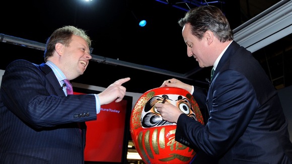 David Cameron colours in the eye of a Daruma doll