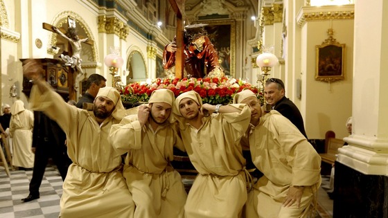 Statue bearers strain as they prepare to lift the statue of Christ the Redeemer at the start of a Good Friday procession in Valletta, Malta