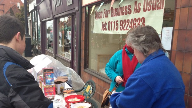 Shopkeepers promoting their goods and urging customers to stay loyal throughout the disruption