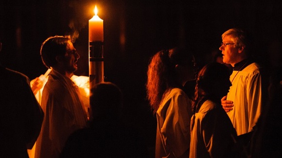 Clergy light the Paschal candle during the Easter vigil mass at Westminster Cathedral