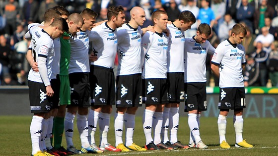 Derby County players observe a minute's silence in memory of the six children who lost their lives in a house fire on Victory Road.
