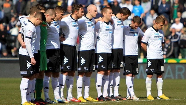 Derby County players observe a minute's silence in memory of the six children who lost their lives in a house fire on Victory Road.