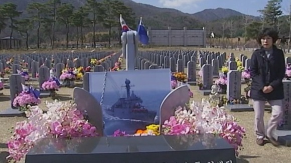 A mother visits her son's grave in a war cemetery in South Korea