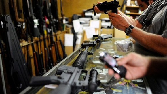 Customers look at rifles for sale at the Bullet Hole gun shop in Sarasota, Florida