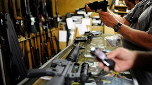Customers look at rifles for sale at the Bullet Hole gun shop in Sarasota, Florida