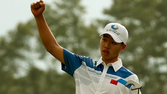 Guan Tianlang of China celebrates sinking a birdie on the 18th green during first round play in the 2013 Masters